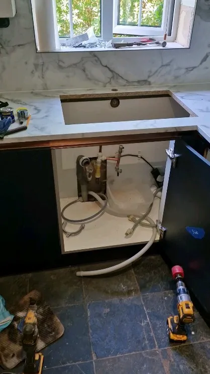 A kitchen under construction with a sink and a dishwasher.