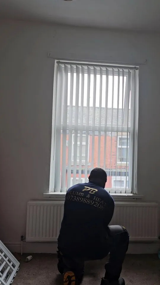 A man sitting on a chair in front of a window.