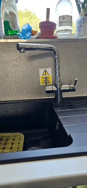 A black sink sitting under a window next to a counter.
