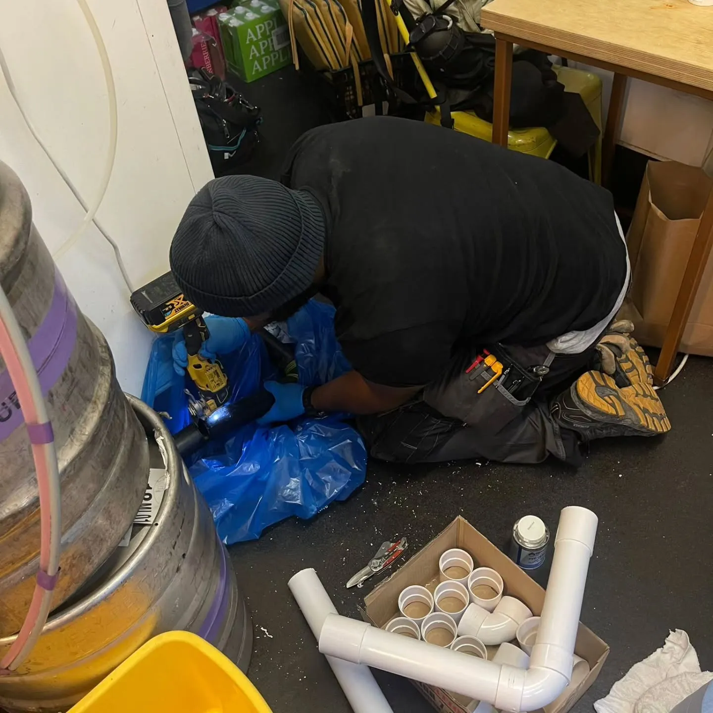 A man working on a pipe in a garage.