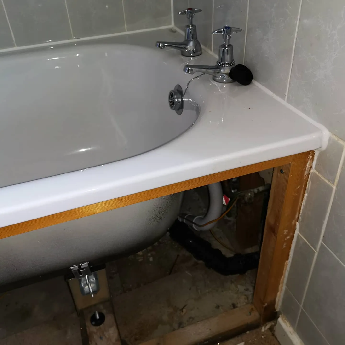 A white bath tub sitting under a bathroom sink.