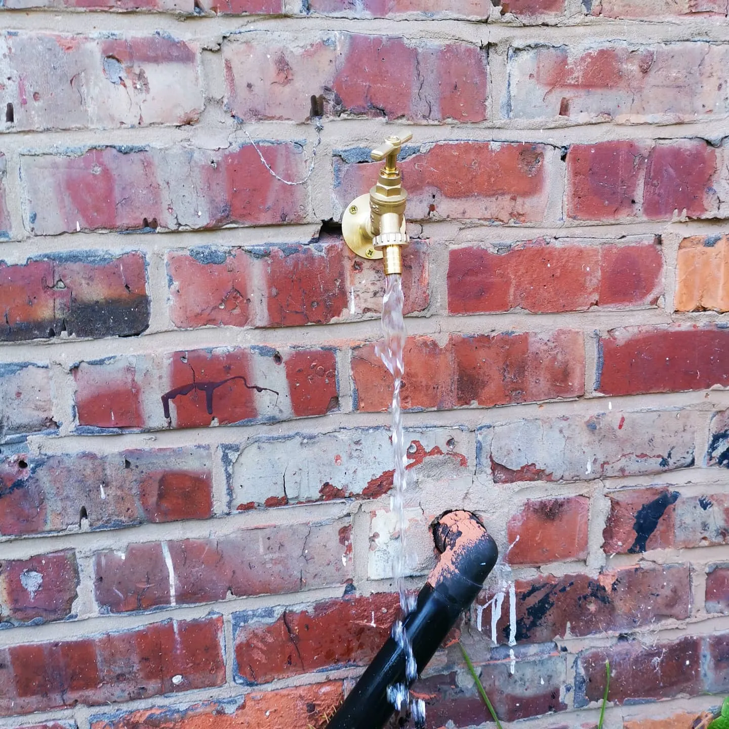 A fire hydrant spewing water out of it's spout.
