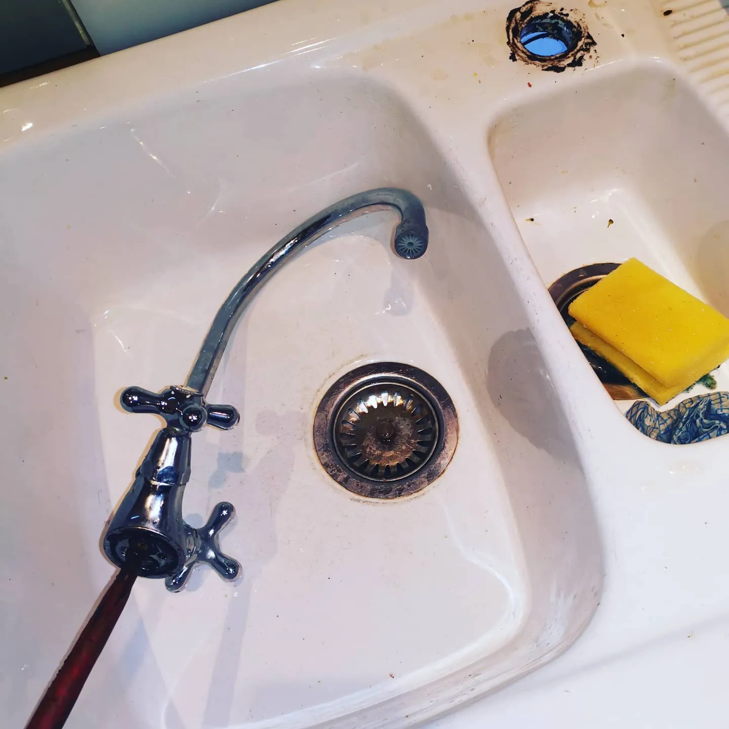A sink that has a yellow sponge on it.